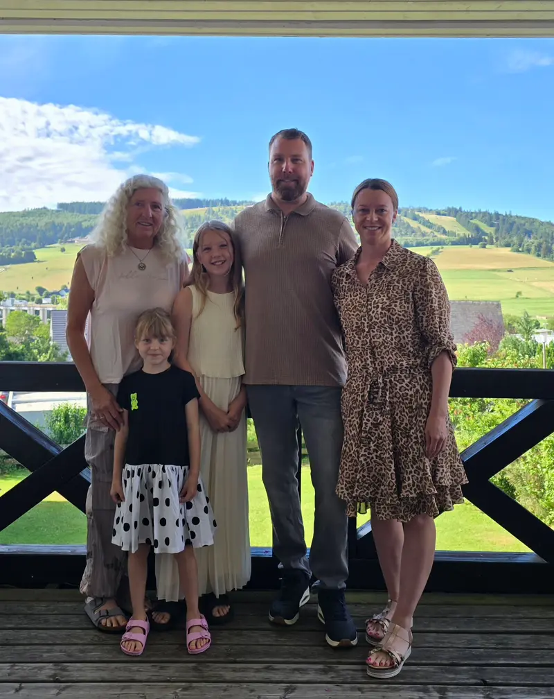 Die Gastgeberfamilie auf dem Balkon mit Blick auf die Berge