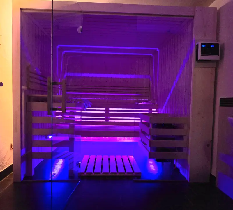 Finnische Sauna mit Glasfront und farbigem Licht